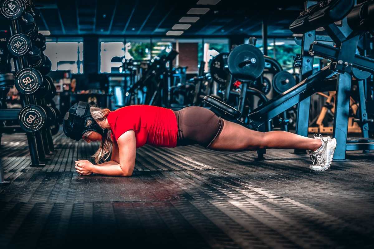 a woman doing plank in a gym